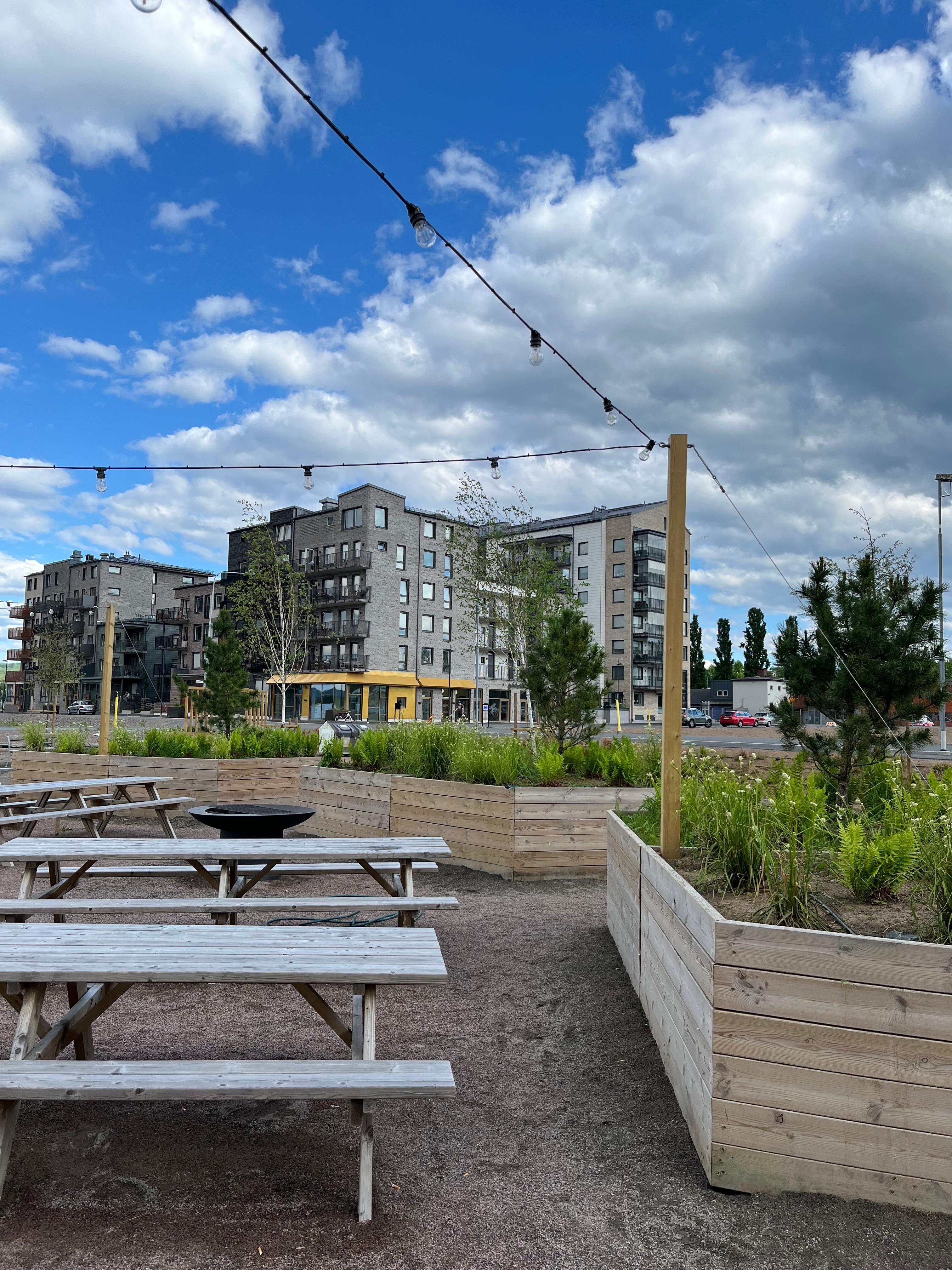 Sittplatser och bord bredvid en odlingslåda med blommor