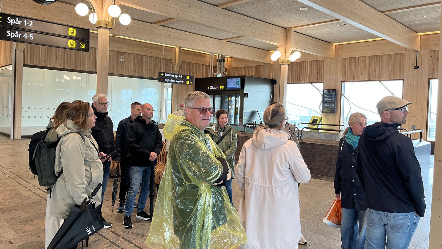 En grupp människor står i en vänthall för tåg.