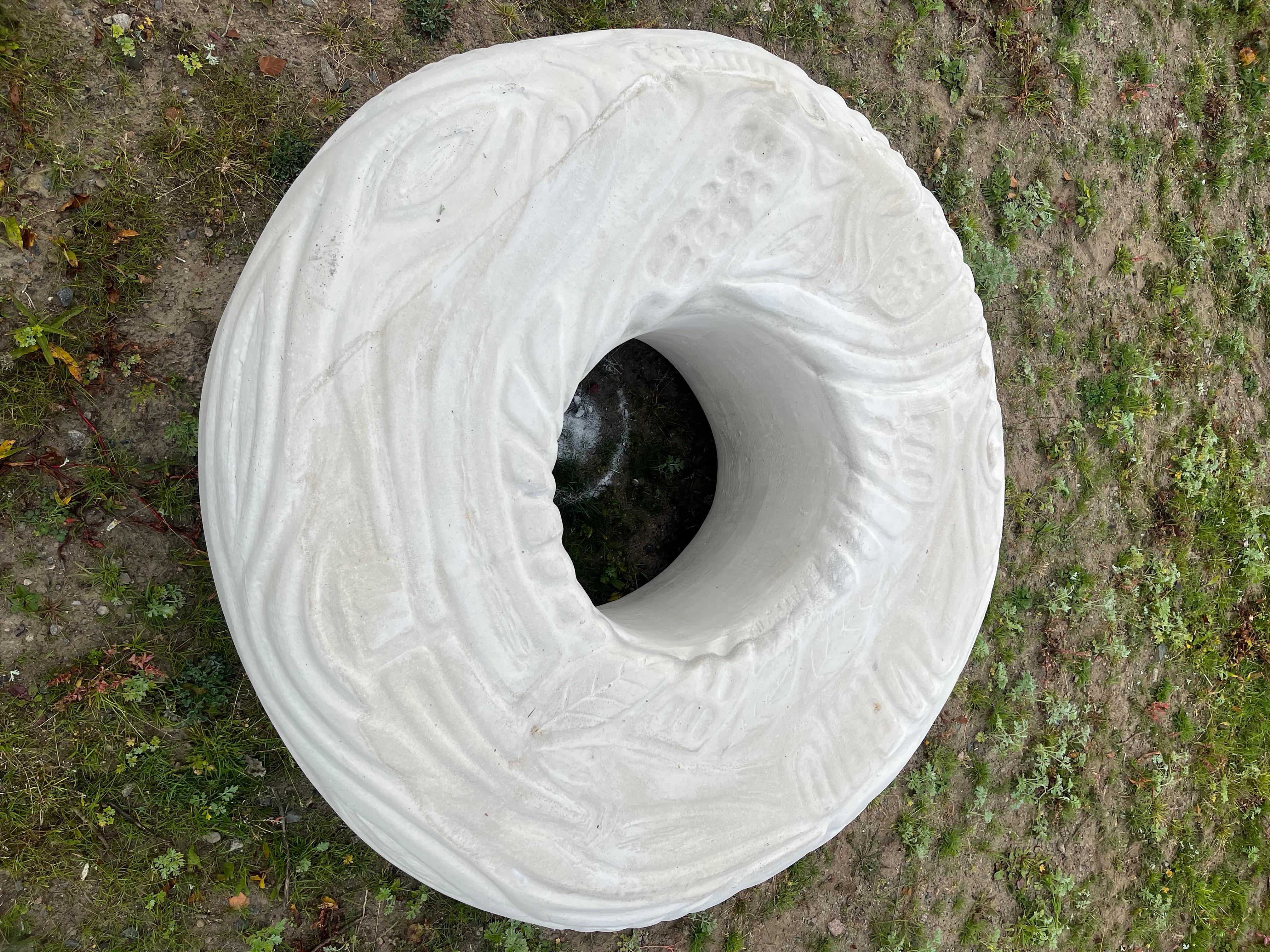 Munken är gjord i ljusgrå betong och glasyren på munken bildar olika mönster.