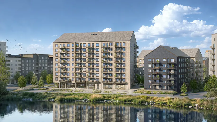 En beige byggnad med balkonger framför en spegelblank sjö.